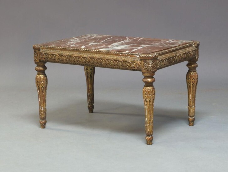A Louis XVI or later gilt side table, the rectangular red and and white variegated marble top, above guilloche and foliate carved frieze on fluted legs to toupie feet, possibly originally a stool, 43cm high, 68cm wide, 48cm deep