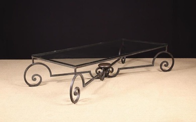 A Low Glass-topped Coffee Table on a Wrought Iron Base. The rectangular top, resting on a X-framed b