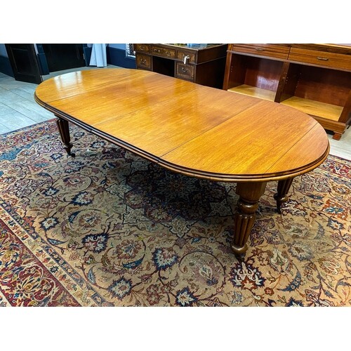 A MAHOGANY EXTENDING DINING TABLE The moulded top above a p...