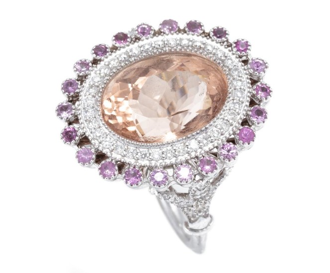 A MORGANITE SAPPHIRE AND DIAMOND COCKTAIL RING; centring a millegrain set oval morganite of approx. 7.00ct within a surround of 34 r...
