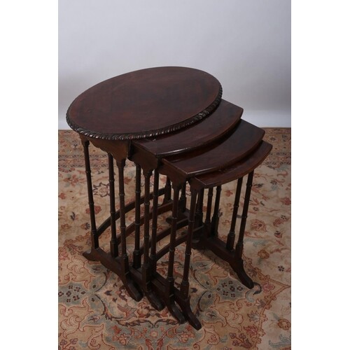A NEST OF QUARTETTO MAHOGANY CROSS BANDED TABLES the oval to...