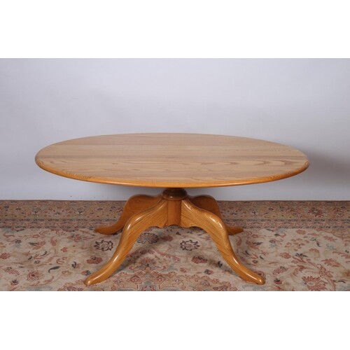 A VINTAGE ERCOL ELM COFFEE TABLE of oval outline on quadrupe...