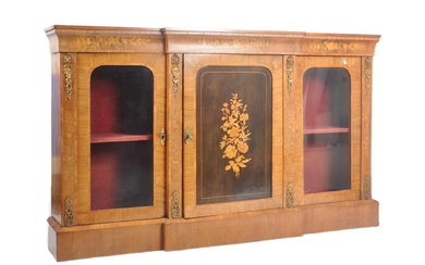 A Victorian 19th century walnut & marquetry breakfront sideboard credenza having a flared top over an inlaid and detailed fitted frieze. Central single cupboard door with inlaid panel with decorative corbels to sides. The central door flanked by...