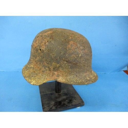 A WWII German MK42 helmet on stand, in well worn condition w...