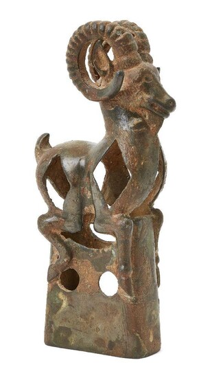 A Western Asiatic openwork bronze finial in the form of a mountain goat with with long curved horns, pointed ears and short upright tail, set atop an openwork rectangular base, circa 1st Millennium B.C./A.D., 20.6cm high Provenance: Private...