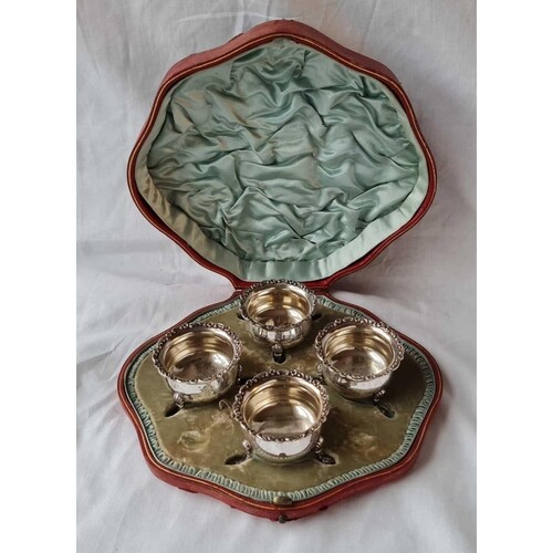 A boxed set of four late Victorian salts with cast silver ri...