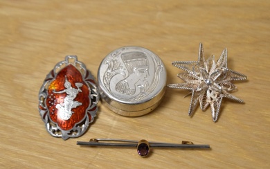 A collection of silver brooches including one of a filigree starburst design and a Thai red enamel