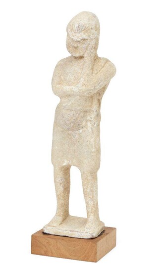 A hollow terracotta standing theatrical figure wearing the mask of a comic actor wearing, resting his face with against his left hand, with pot belly and knee-length tunic, on an integral base, Not Ancient, 25.3cm high