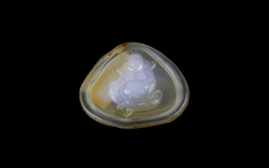 A lovely translucent chalcedony pebble amulet of Putai, the Happy Buddha, with naturally speckled outer rim, W. 7cm. Condition: excellent.