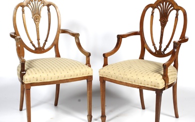 A pair of 20th century Hepplewhite style dining chairs. Each with trefoil shaped pierced foliate shield back, with striped stuffover seats, on square tapering legs and spade feet, 96cm high