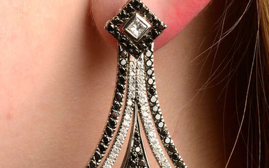 A pair of diamond and black gem earrings.