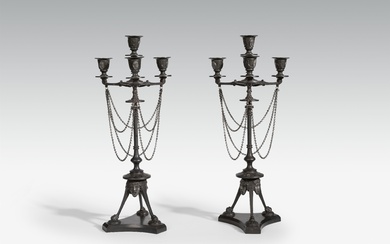 A pair of four flame cast iron candelabra