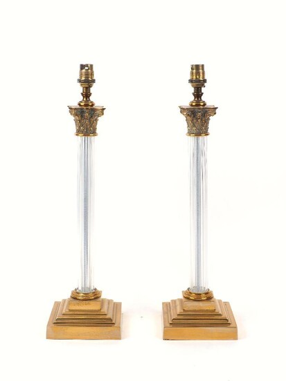 A pair of lucite and brass column table lamps, late 20th century, each with Corinthian capital and stepped square base, 48.5cm high (2)