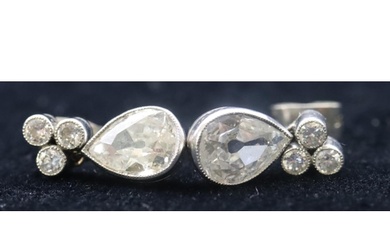 A pair of white gold drop diamond earrings with a pear shape...