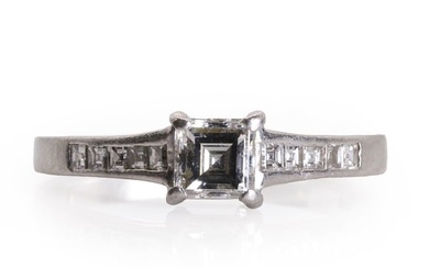 A platinum single stone diamond ring with diamond set shoulders