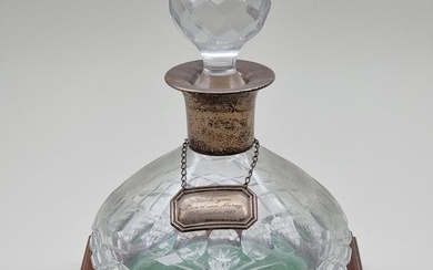 A silver mounted cut glass decanter and stopper, on mahogany...