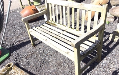 A teak garden bench of slatted construction with dished seat,...