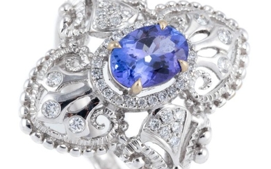 AN 18CT WHITE GOLD TANZANITE AND DIAMOND RING; Edwardian inspired design centring an oval cut tanzanite of approx. 0.92ct to surroun...