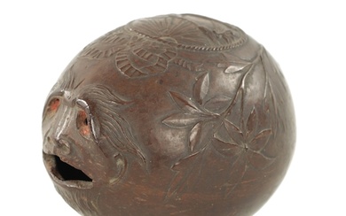AN EARLY 19TH CENTURY EASTERN CARVED COCONUT BUGBEAR MONEYBO...