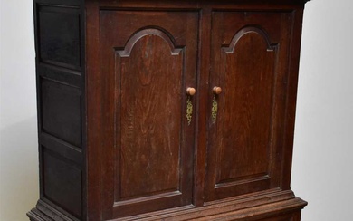An 18th century oak livery cupboard, with two arched panelled...