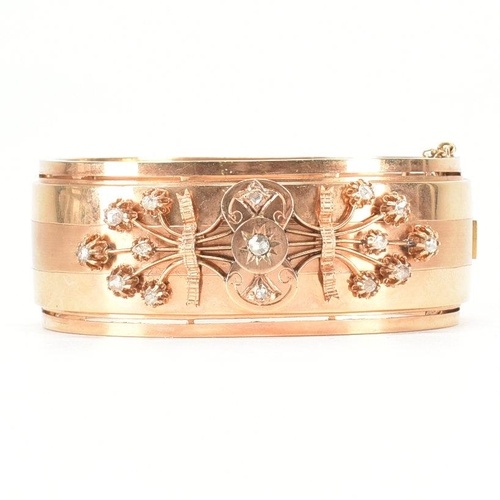 An early 20th Century 18ct gold and diamond bangle. The hing...