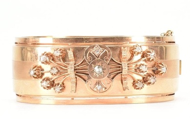 An early 20th Century 18ct gold and diamond bangle. The hing...