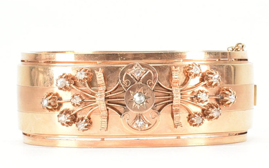 An early 20th Century 18ct gold and diamond bangle. The hinged bangle set with rose cut diamonds in a spray design to a wide band with pierced border. French assay marks to clasp. Weight 31.8g. Internal circumference approx 18cm.