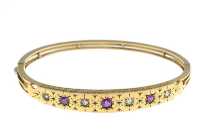 An early 20th century 9ct gold circular-shape ruby and diamond hinged bangle.