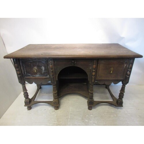 An early English oak sideboard having centre arch flanked by...