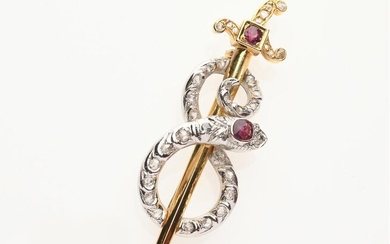 BROCHE "Serpent et épée" en or jaune 750/°° et platine 850/°° ornée de rubis et de diamants taillés en rose. H. : 7 cm. PB : 20,5 g. Une pierre blanche, petites égrisures.