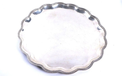 Circular tray with a wavy silver wing, the border decorated with torsos gadroons.