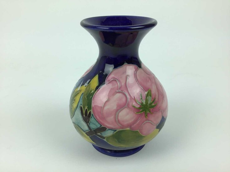 Moorcroft pottery vase decorated in the Magnolia pattern on blue ground, impressed marks to base, 13cm high