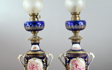 Paire de lampes à pétrole, pied en porcelaine, probablement de Sèvres, réservoir en verre, décor...