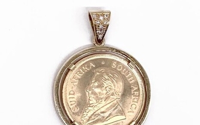 Piece in Krugerrand yellow gold dating from 1988 with the profile of Paul Kruger, the piece mounted as a pendant, the bélière adorned with nine modern brilliant-cut diamonds. Gross weight: 43.8 g Diameter piece: 32 mm A yellow gold coin with diamonds
