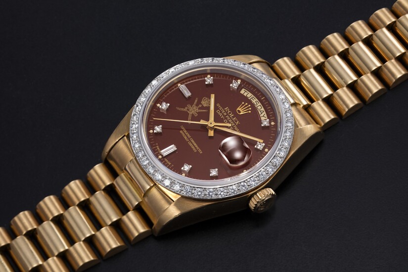 ROLEX, A GOLD AND DIAMOND-SET OYSTER PERPETUAL DAY-DATE WITH “KHANJAR” INSIGNIA ON THE "OXBLOOD" DIAL, REF. 18048