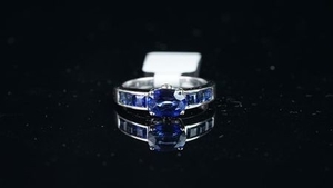 Sapphire and diamond ring, mounted in white metal stamped 18K, central oval sapphire claw set, with three square cut sapphires...