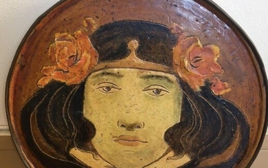 Stoneware medallion representing a woman's face crowned with flowers, Art Nouveau period, circa 1900
