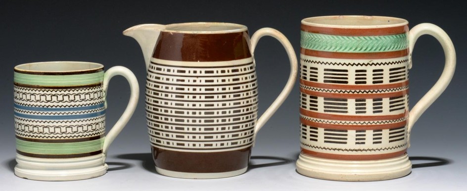 TWO CYLINDRICAL SLIP-DIPPED PEARLWARE MUGS AND A BARREL SHAP...