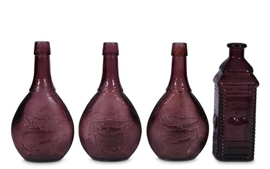 A collection of four American purple glass bottles probably...