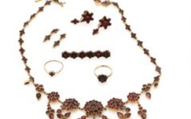 1927/1171 - A garnet jewellery collection of gilded metal comprising a necklace, two rings, a pair of ear screws and a brooch. Size 56 and 58.5. (6)