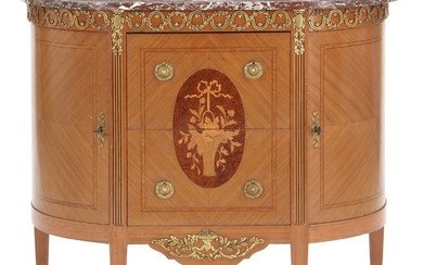 A Louis XVI style mahogany and rootwood commode with gilt-bronze mountings and marble top. Ca. 1930. H. 90 cm. W. 102 cm. D. 45 cm.