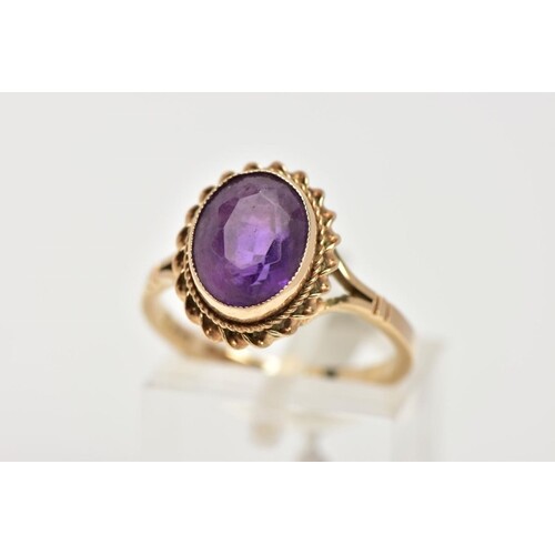 A 9CT GOLD AMETHYST DRESS RING, designed with an oval cut am...