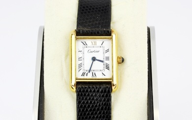 A Cartier 18k yellow gold electroplated wristwatch on an embossed black leather strap.