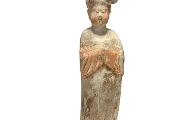 A Chinese pottery figure of a court lady Tang dynasty Modelled standing...