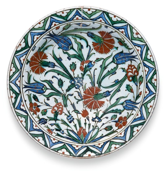 A LARGE IZNIK POLYCHROME POTTERY DISH WITH FLORAL BORDER, TURKEY, CIRCA 1580-85