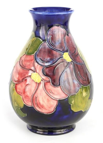 A WALTER MOORCROFT FOOTED OVOID VASE decorated in