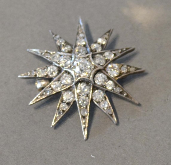 A White Gold Brooch in the form of a star with central diamo...