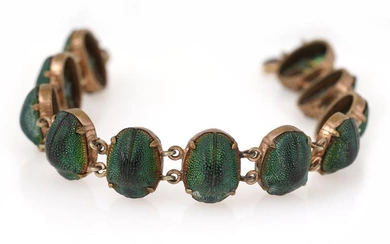 A bracelet set with numerous scarabs, mounted in brass. L. 19 cm....