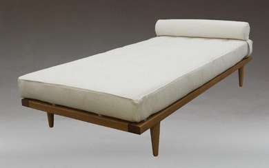 A contemporary daybed, of recent manufacture, with buttoned and cream upholstered seat with single bolster cushion, on a walnut frame with tapering beach supports, 59cm high,190cm wide, 90cm deep