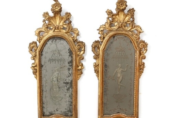 A pair of carved Italian Régence giltwood mirrors. Mirror glasses with etched figural motifs. Ca. 1730. H. 73 cm. W. 28 cm. (2).